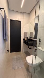 a bathroom with a toilet and a black door at Smart Residence Moderno in Santarém +4 photos