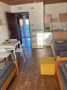 een kamer met bedden, een tafel en een keuken bij Penzion Hevera in Kuchařovice