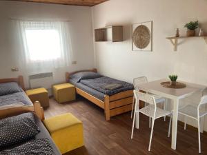 een kamer met een bed, een tafel en stoelen bij Penzion Hevera in Kuchařovice