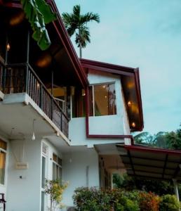 een wit gebouw met een balkon en een veranda bij Rainforest Holiday Inn in Deniyaya +134 foto's