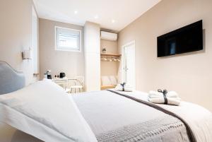 een slaapkamer met een wit bed en een flatscreen-tv aan de muur bij Residence Briona in Domodossola