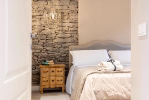 a bedroom with a bed and a stone wall at Residence Briona in Domodossola