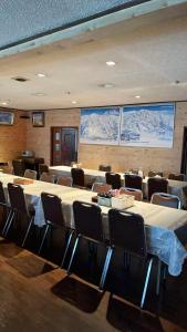 een vergaderruimte met tafels en stoelen en posters aan de muur bij 苗場ウッドインだいまる in Yuzawa