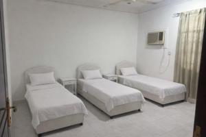 ein Krankenhauszimmer mit 2 Betten und einem TV in der Unterkunft Amour Hostel in Seeb + 1 Foto