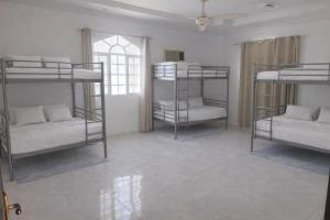 ein Zimmer mit drei Etagenbetten und einem Fenster in der Unterkunft Amour Hostel in Seeb