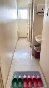 a row of seven differently colored shoes in a bathroom at 苗場ウッドインだいまる in Yuzawa +37 photos