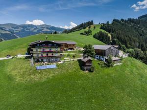 a large house on a hill with green grass at Bio Bauernhof Holzegghof in Zell am See in Erlberg