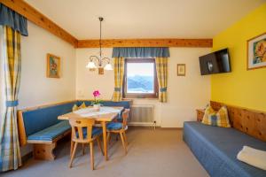 a living room with a table and a couch at Bio Bauernhof Holzegghof in Zell am See in Erlberg