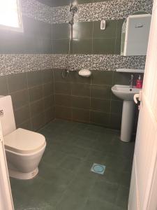 łazienka z toaletą i umywalką w obiekcie Amour Hostel w mieście As-Sib