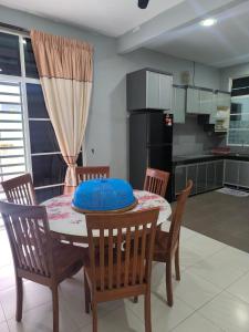 a kitchen with a table with a blue cushion on it at Nani Homestay in Kampong Bukit Kuang