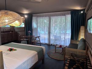 ein Hotelzimmer mit Bett, Tisch und Stühlen in der Unterkunft Serenity Sands - Island Glamping in Bounty Island