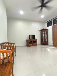 a living room with a ceiling fan and a table at Nani Homestay in Kampong Bukit Kuang