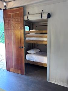 eine offene Tür zu einem Schlafzimmer mit Etagenbetten in der Unterkunft Serenity Sands - Island Glamping in Bounty Island + 25 Fotos