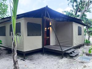 ein weißes Zelt mit blauem Dach und einer Veranda in der Unterkunft Serenity Sands - Island Glamping in Bounty Island