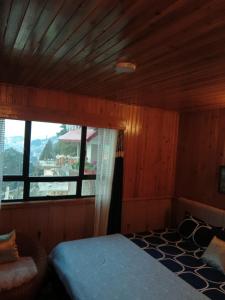 a bedroom with a bed and a large window at Ghising Newas Homestay in Jālāpahār +25 photos