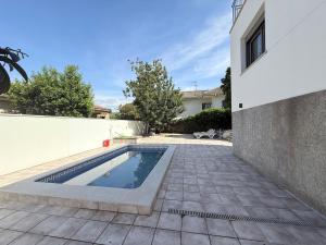 a swimming pool in a yard next to a building at The White House in Calafell
