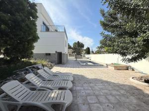 a row of white chairs sitting outside of a building at The White House in Calafell