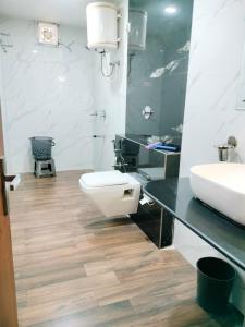 a bathroom with a white toilet and a sink at Hotel Allseasons in Roorkee