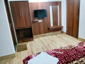 a room with a bed and a flat screen tv at Hotel Allseasons in Roorkee
