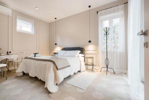 een witte slaapkamer met een bed en een tafel bij Residence Briona in Domodossola