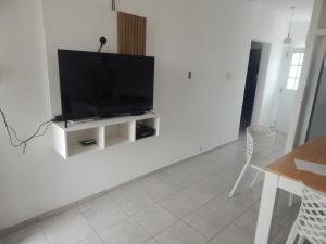 a living room with a flat screen tv on a white wall at San Cayetano in Paraná