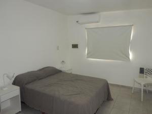 a bedroom with a bed and a white wall at San Cayetano in Paraná