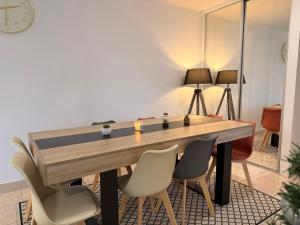 a dining room with a wooden table and chairs at Le Beauséjour ! Beaux volumes, idéals pour un séjour confortable et reposant in Saint-Herblain