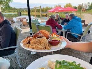 een persoon met een bord voedsel op een tafel bij Bungalow Sun am See in Zirkow +11 foto's