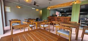 une salle à manger avec des tables et des chaises en bois dans l'établissement Bela Ahangama, à Ahangama