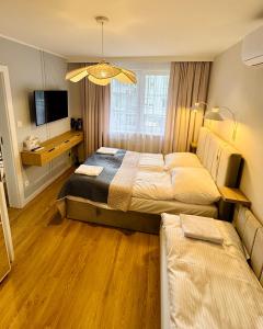 a hotel room with two beds and a television at Modrzewiowa Przygoda in Debina