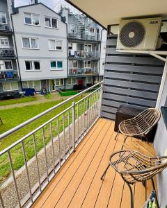 a balcony with two chairs and an air conditioner at Modrzewiowa Przygoda in Debina