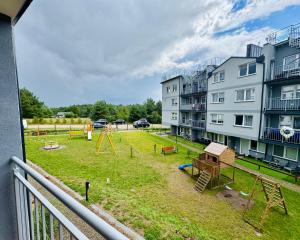 an apartment with a playground in a yard at Modrzewiowa Przygoda in Debina +3 photos