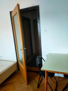 una stanza con tavolo, porta e sedia di Apartman Branko Radicević a Negotin