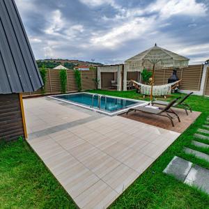 a backyard with a swimming pool and a gazebo at Beloris Bungalov in Erenköy