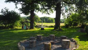 een cirkel van boomstronken in een park met een speeltuin bij La Vache Bleue in Saint-Pierre-de-Fursac