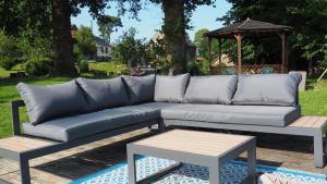 een bank en een tafel in de tuin bij La Vache Bleue in Saint-Pierre-de-Fursac