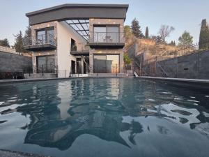 a house with a swimming pool in front of a house at Cesia Boutique - ססיה סוויטות בוטיק in Biriyya