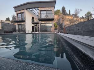 a house with a swimming pool in front of a house at Cesia Boutique - ססיה סוויטות בוטיק in Biriyya