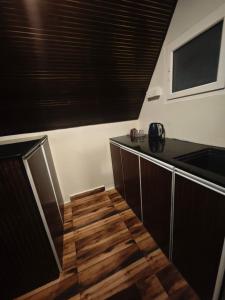 a kitchen with a counter and a wooden floor at Colomb Beach Cottages in Patnem