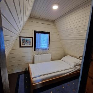 a small room with a bed and a window at Winter house Vlasic in Šišava