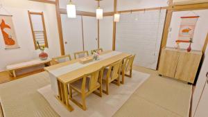 a dining room with a wooden table and chairs at MyBound Homestay Zushi in Zushi