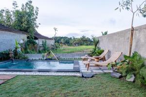 a backyard with a pool with two chairs and a swing at Bagus Bandem Villa in Ubud