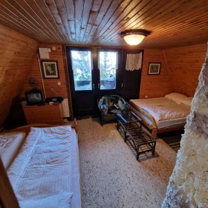 an attic room with two beds and a tv at Winter house Vlasic in Šišava +7 photos