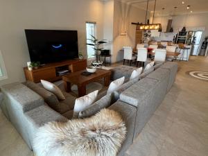 ein Wohnzimmer mit Sofa und Flachbildfernseher in der Unterkunft Villa Serenity Beachfront Bali in Pengastulan