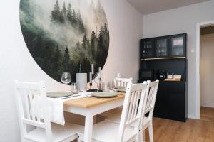 una sala da pranzo con tavolo e sedie bianchi di DAS GRÜNE NEST Münsterland Living a Drensteinfurt