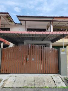 a wooden fence in front of a house with a gate at Tambun - Near LWOT, PLUS Highway Access ,Sunway & Pantai Hosp in Tambun