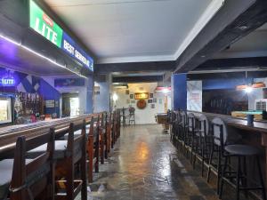 a bar with a row of chairs in a restaurant at Bostons Lodge & Restaurant in Jan Kempdorp