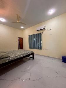 an empty room with a bed and a ceiling fan at VAISHVI Homestay in Kāsarkod +4 photos