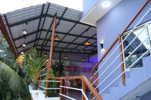 a lobby with stairs and plants in a building at VAISHVI Homestay in Kāsarkod