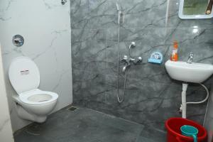 a bathroom with a shower and a toilet and a sink at VAISHVI Homestay in Kāsarkod